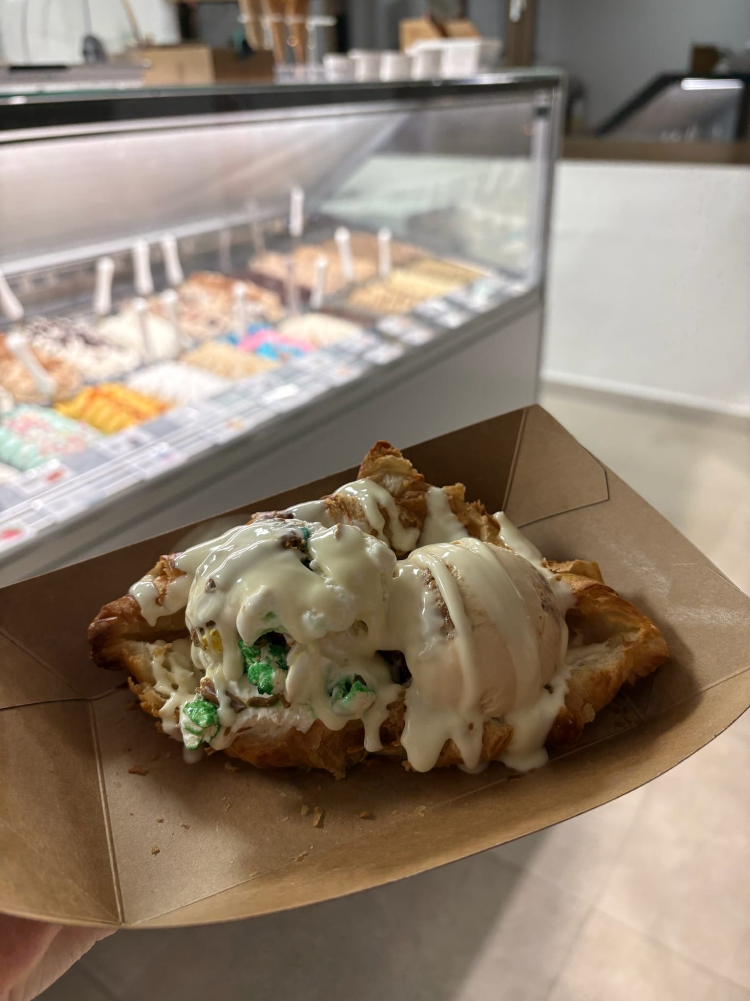 Berenar del Faro with two scoops (blue and chocolate) and cream, next to the hand-painted "Berenar del faro €5.50" sign